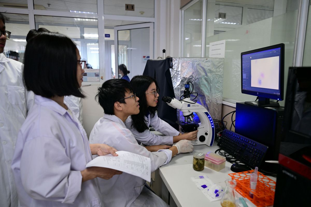 Học sinh chăm chú quan sát vi sinh vật qua kính hiển vi tại Trạm 4 